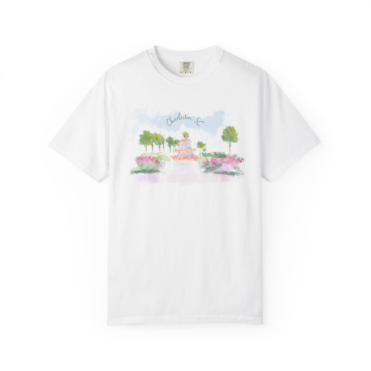 White t-shirt featuring a hand-painted illustration of the Pineapple Fountain in Charleston, SC surrounded by palm trees and colorful flowers, created by Rebecca Illustrated.