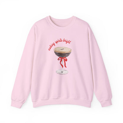 Pink sweatshirt with illustrated espresso martini glass tied with a red bow and text ‘making spirits bright,’ artwork by Rebecca Illustrated