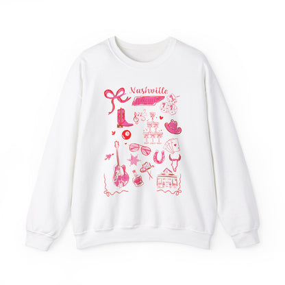 White sweatshirt with pink Nashville-themed illustrations including cowboy boots, guitar, hat, champagne, dice, horseshoe, sunglasses, and Music City icons, artwork by Rebecca Illustrated