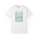 White t-shirt featuring a hand-drawn architectural illustration in teal of a European-style villa framed with a scalloped border, created by Rebecca Illustrated.