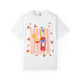White t-shirt with a hand-painted Aperol spritz cocktail illustration, orange slice garnish, striped background, and scattered citrus details, designed by Rebecca Illustrated.
