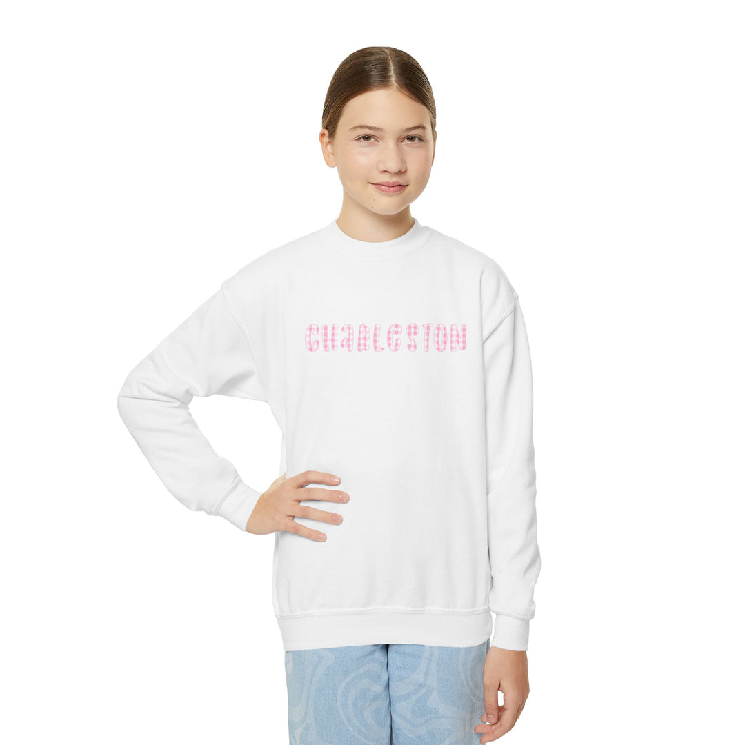 Youth white crewneck sweatshirt featuring pink gingham ‘Charleston’ lettering on the front, illustrated by Rebecca Illustrated.