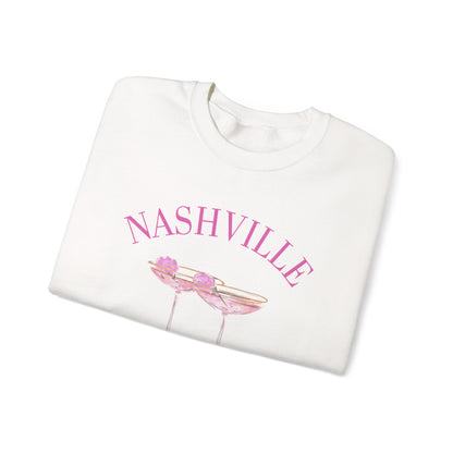 White crewneck sweatshirt with pink ‘Nashville’ bachelorette social club artwork featuring champagne coupe illustration, hand designed by Rebecca Illustrated