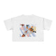 White cropped t-shirt featuring a hand-painted picnic still life with rosé wine, citrus fruits, sunglasses, flowers, and pastel blue stripes by Rebecca Illustrated."