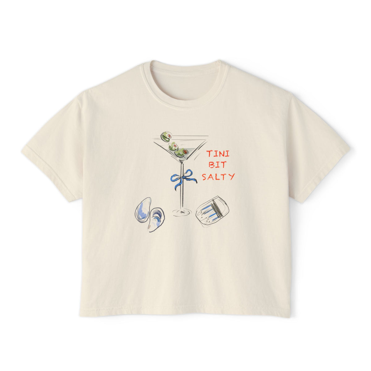 Cream cropped t-shirt featuring a hand-drawn dirty martini with olives, seashells, a bow on the stem, and the text ‘Tini Bit Salty’ by Rebecca Illustrated