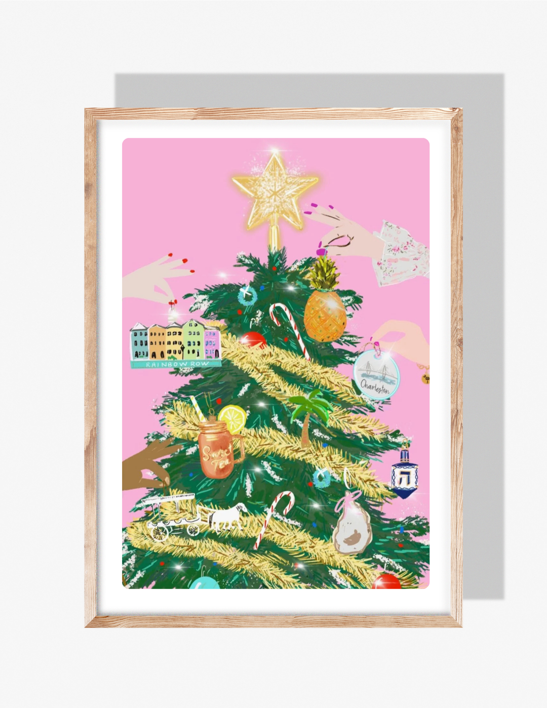 A colorful illustration by Rebecca Illustrated featuring a Christmas tree decorated with Charleston-themed ornaments—including Rainbow Row, a pineapple, sweet tea, a palm tree, an oyster, and the Ravenel Bridge—set against a pink background with hands placing ornaments.