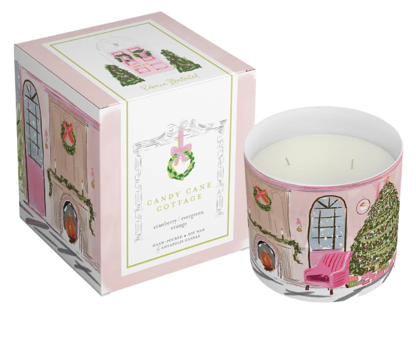 Luxury holiday candle with illustrated Candy Cane Cottage interior scene, boxed gift candle featuring original artwork by Rebecca Illustrated.