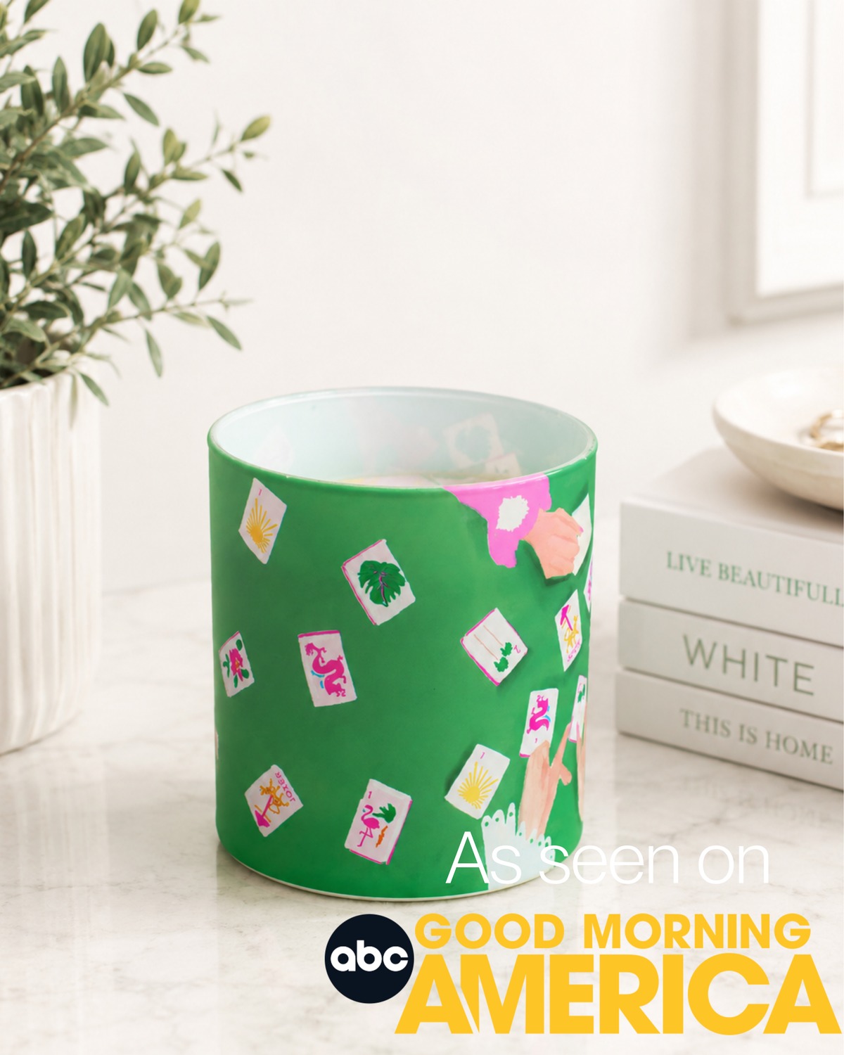 Green container with colorful stickers on a white surface, with 'Good Morning America' branding.