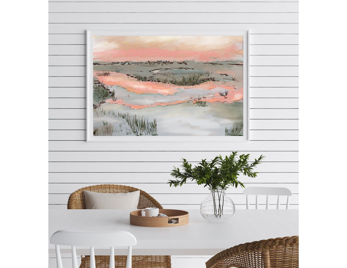 A soft pastel landscape illustration by Rebecca Illustrated featuring a marsh at sunset with pink reflections, grasses, and calm coastal waters displayed in a white frame on a shiplap wall.