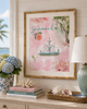 Decorative setting with a framed artwork of a fountain and peach, books, and a lamp.