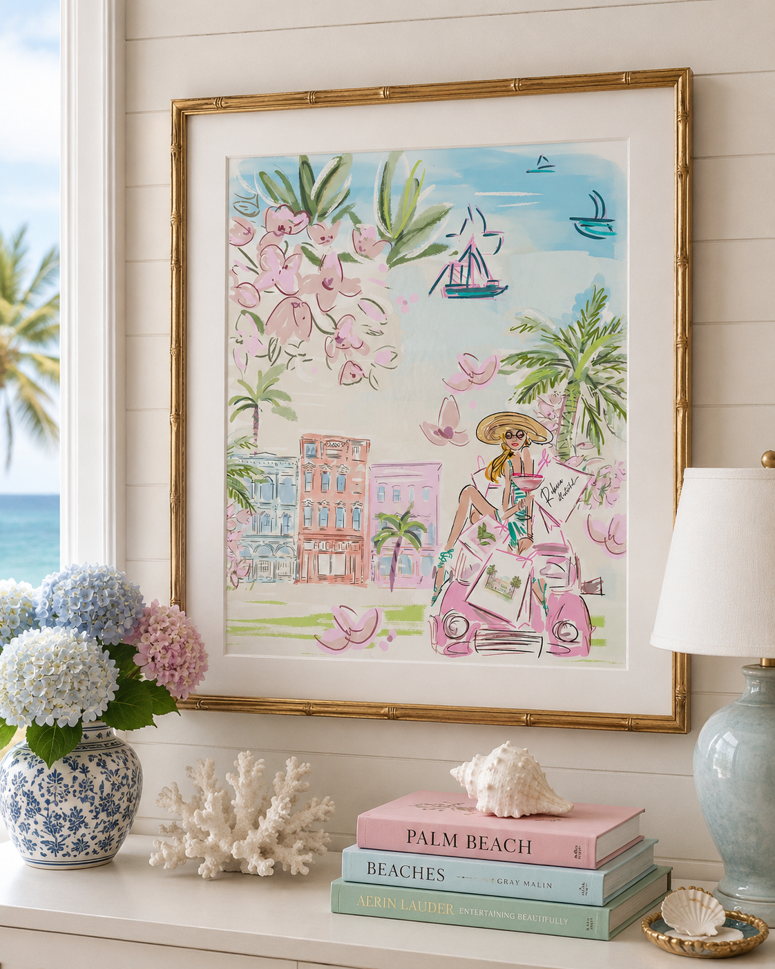Framed artwork of a woman in a pink dress with palm trees and a cityscape, displayed on a shelf with decorative items.