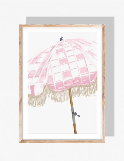 A pastel pink checkered beach umbrella with fringe, illustrated by Rebecca Illustrated, against a clean white background.